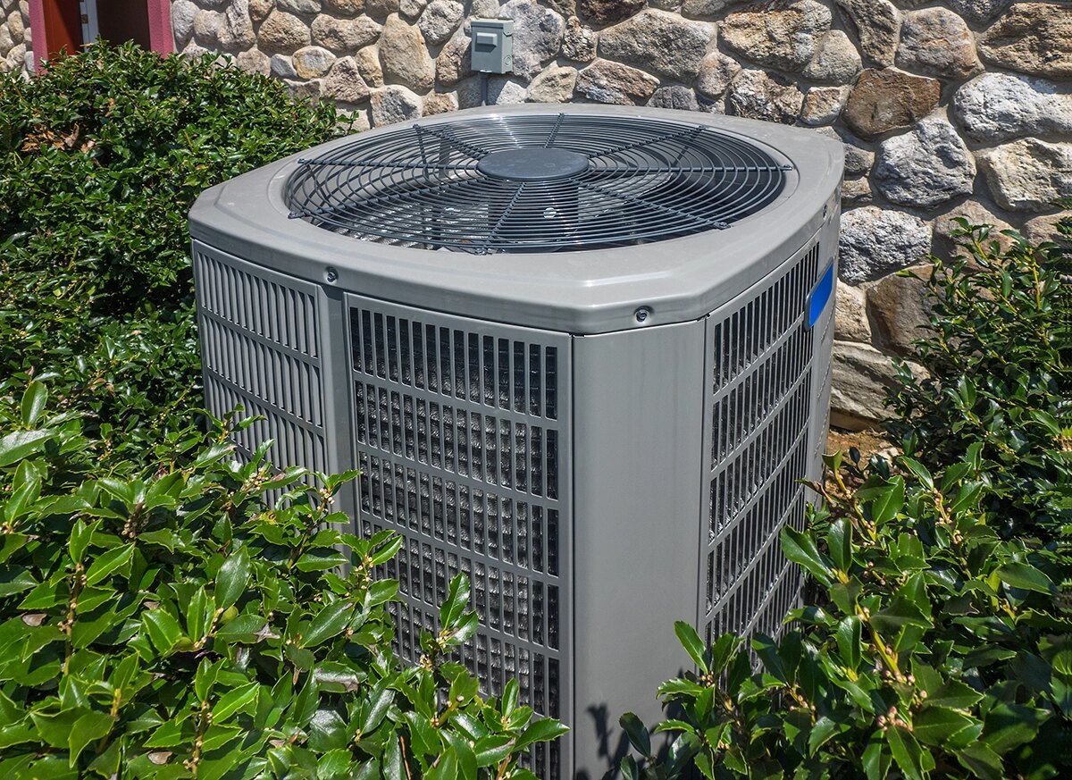 Outdoor condenser beside a stone wall